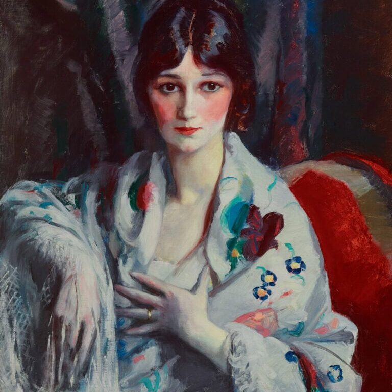 portrait of a woman with black hair sitting and wearing a white shall with flowers on it